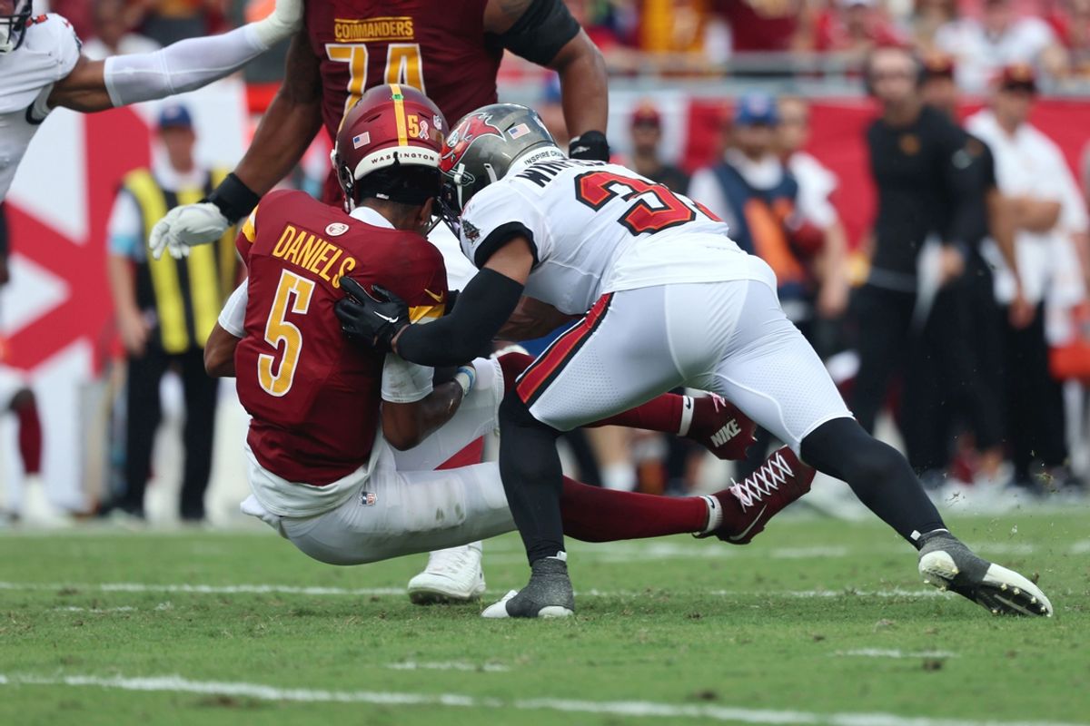 Sep 8, 2024; Tampa, Florida, USA;  Tampa Bay Buccaneers safety Antoine Winfield Jr. (31) hits Washington Commanders quarterback Jayden Daniels (5) in the helment during the first half at Raymond James Stadium. Mandatory Credit: Kim Klement Neitzel-Imagn Images