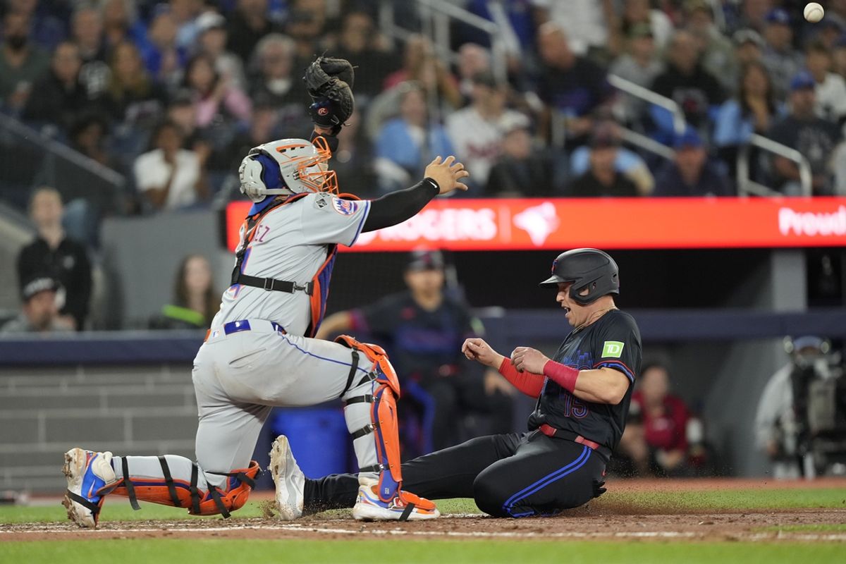 Sep 9, 2024; Toronto, Ontario, CAN; Toronto Blue Jays pinch runner Brian Serven (15) beats the throw to New York Mets catcher Francisco Alvarez (4) to score from third on a sacrifice fly by Toronto Blue Jays left fielder Nathan Lukes (not pictured) during the seventh inning at Rogers Centre. Mandatory Credit: John E. Sokolowski-Imagn Images