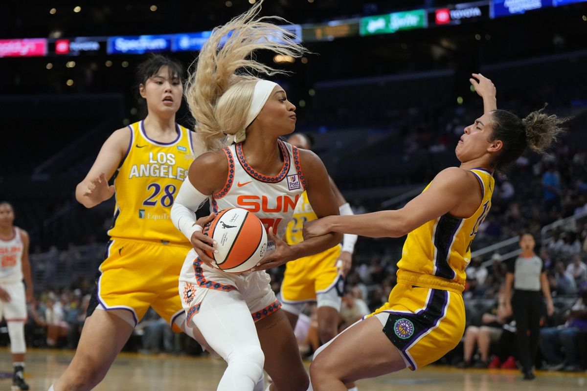 Sep 10, 2024; Los Angeles, California, USA; Connecticut Sun guard DiJonai Carrington (21) is defended by LA Sparks guard Kia Nurse (10) and center Li Yueru (28) in the second half at Crypto.com Arena. Mandatory Credit: Kirby Lee-Imagn Images