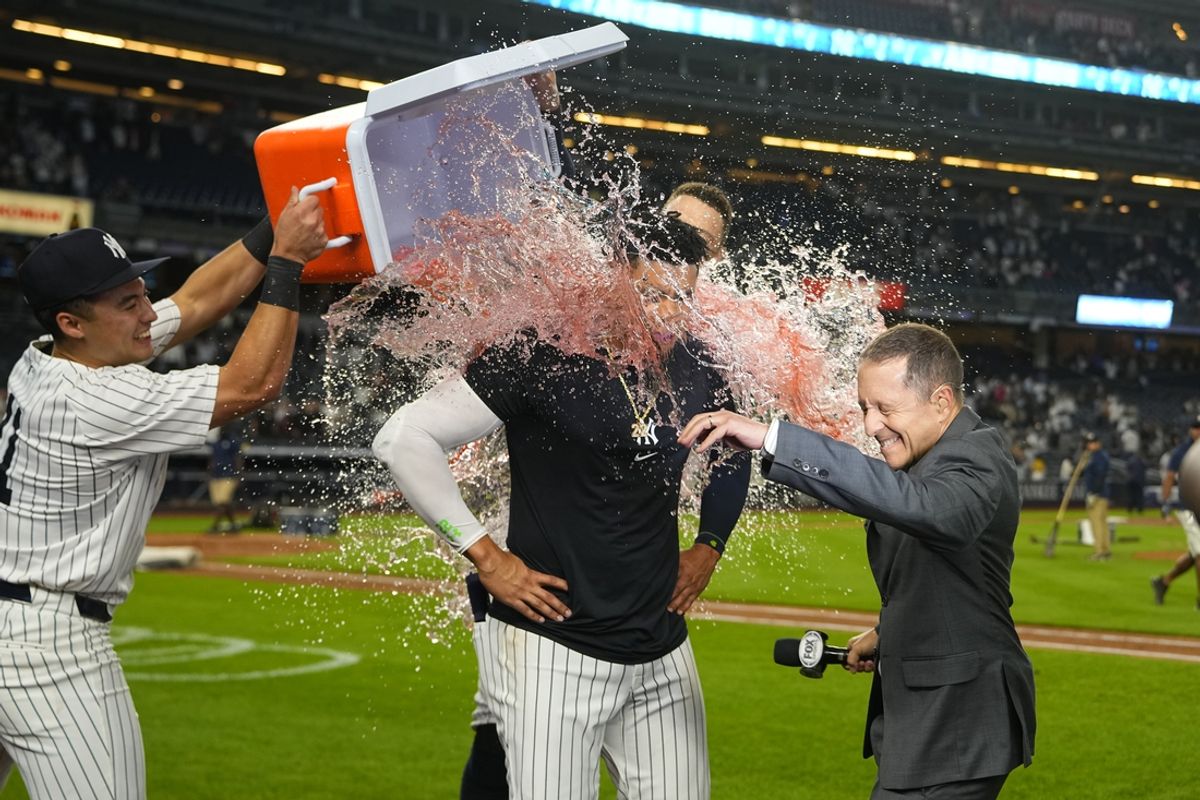 Sep 12, 2024; Bronx, New York, USA; New York Yankees shortstop Anthony Volpe (11) and center fielder Aaron Judge (99) dump gatorade on right fielder Juan Soto (22) for getting the game winning hit while being interviewed by Fox Broadcaster Ken Rosenthal after the game against the Boston Red Sox at Yankee Stadium. Mandatory Credit: Gregory Fisher-Imagn Images