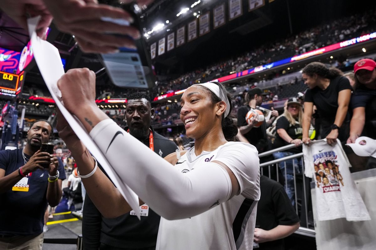 Sep 13, 2024; Indianapolis, Indiana, USA; Las Vegas Aces center A'ja Wilson (22) signs a poster Friday, Sept. 13, 2024, during a game between the Indiana Fever and the Las Vegas Aces on Friday, Sept. 13, 2024, at Gainbridge Fieldhouse in Indianapolis. The Aces defeated the Fever, 78-74.  Mandatory Credit: Grace Smith/USA TODAY Network via Imagn Images