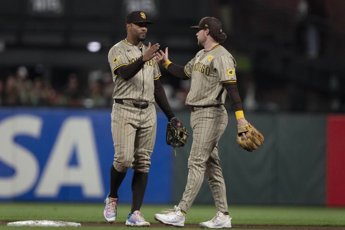 Sep 13, 2024; San Francisco, California, USA;  San Diego Padres second base Xander Bogaerts (2) , left , and first base Jake Cronenworth (9) celebrate after defeating the San Francisco Giants at Oracle Park. Mandatory Credit: Stan Szeto-Imagn Images