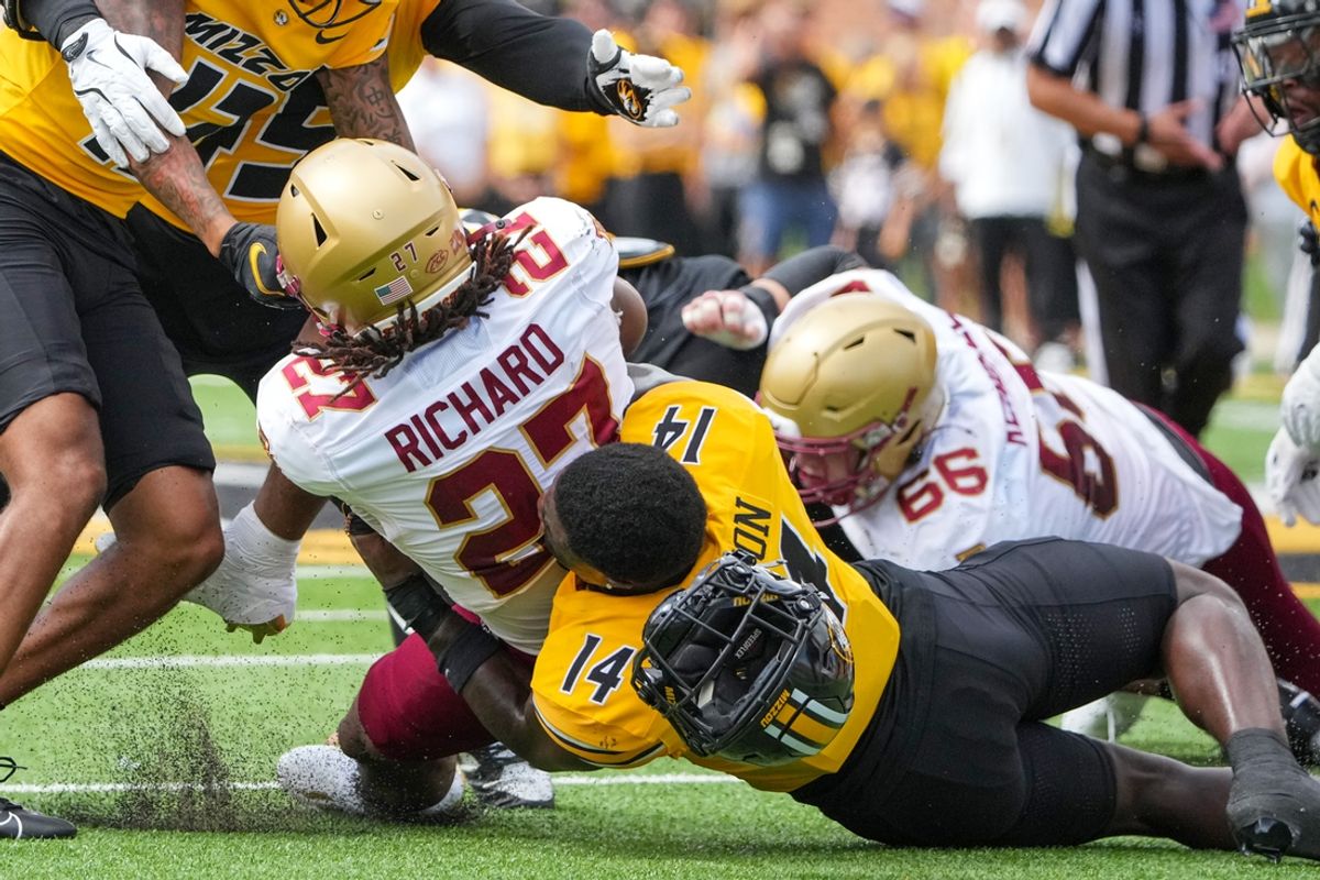 Sep 14, 2024; Columbia, Missouri, USA; Missouri Tigers linebacker Triston Newson (14) looses his helmet while tackling Boston College Eagles running back Turbo Richard (27) during the first half at Faurot Field at Memorial Stadium. Mandatory Credit: Denny Medley-Imagn Images