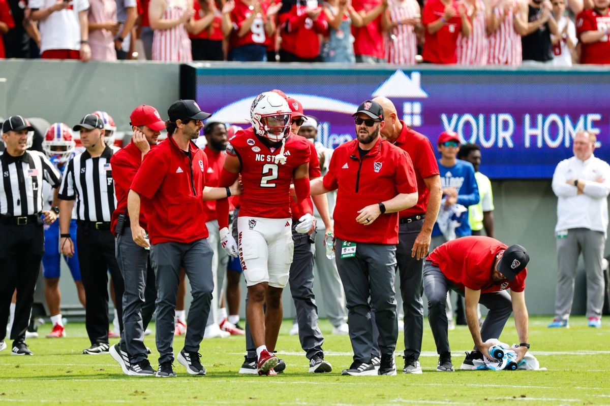 Sep 14, 2024; Raleigh, North Carolina, USA;  North Carolina State Wolfpack quarterback Grayson McCall (2) is assisted during the first half against the Louisiana Tech Bulldogs at Carter-Finley Stadium. Mandatory Credit: Jaylynn Nash-Imagn Images
