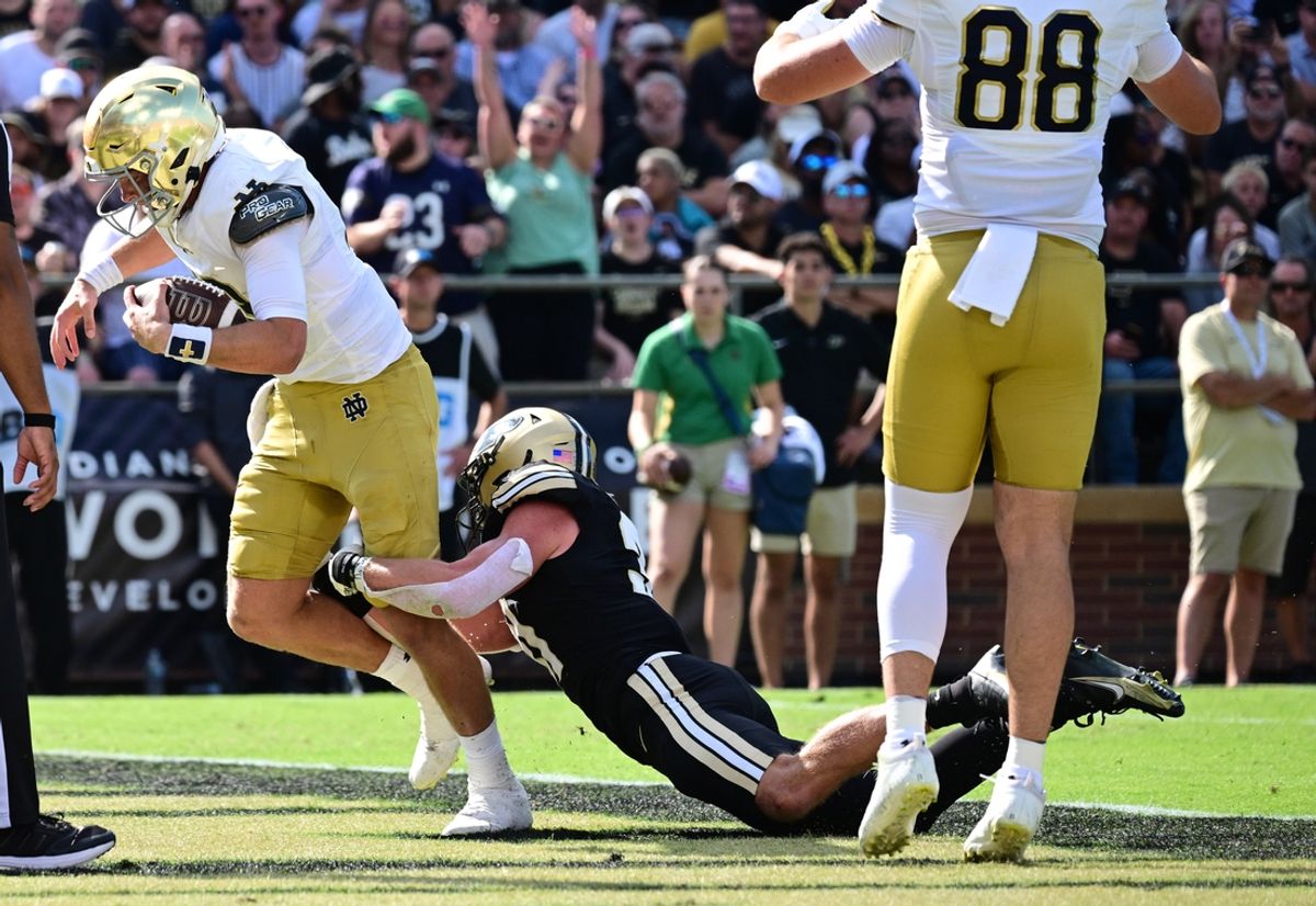Sep 14, 2024; West Lafayette, Indiana, USA; Notre Dame Fighting Irish quarterback Riley Leonard (13) drags Purdue Boilermakers defensive back Dillon Thieneman (31) into the end zone on a touchdown during the first quarter at Ross-Ade Stadium. Mandatory Credit: Marc Lebryk-Imagn Images