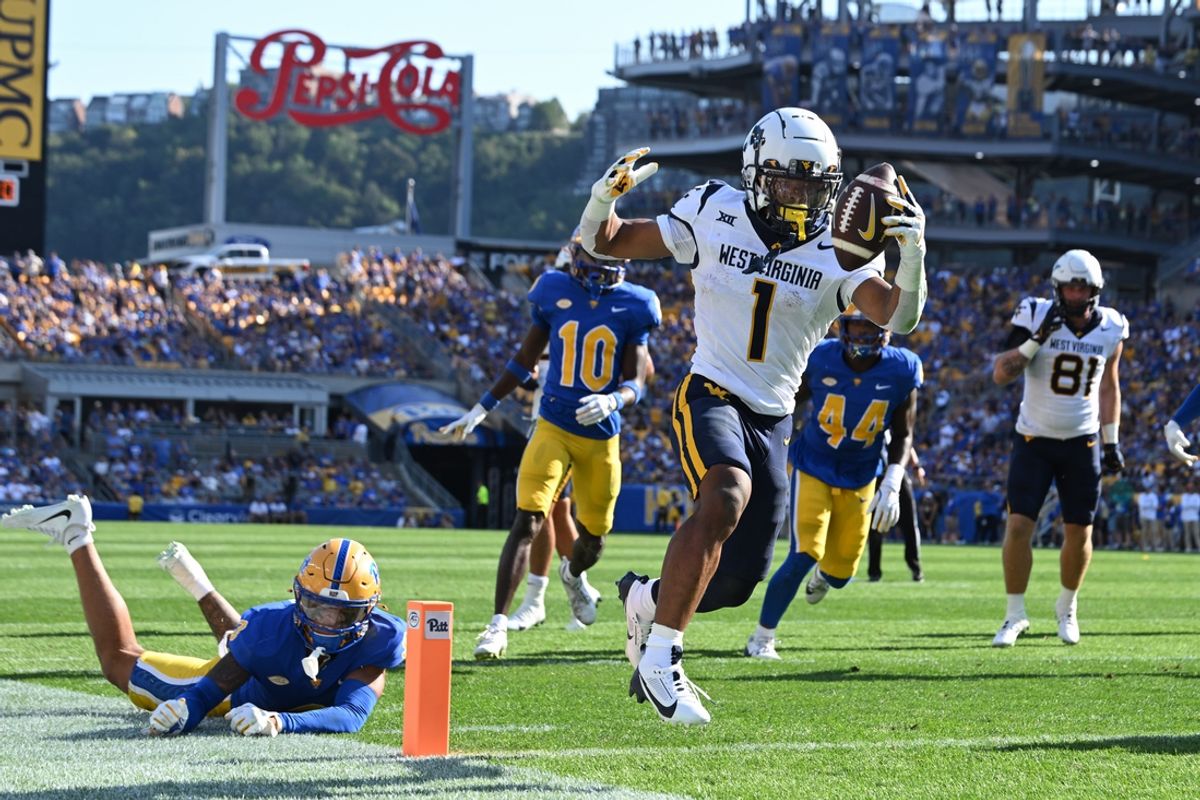 Sep 14, 2024; Pittsburgh, Pennsylvania, USA; West Virginia Mountaineers running back Jahiem White (1) scores a touchdown  against Pittsburgh Panthers defensive back Donovan McMillon (3) during the second quarter at Acrisure Stadium. Mandatory Credit: Barry Reeger-Imagn Images