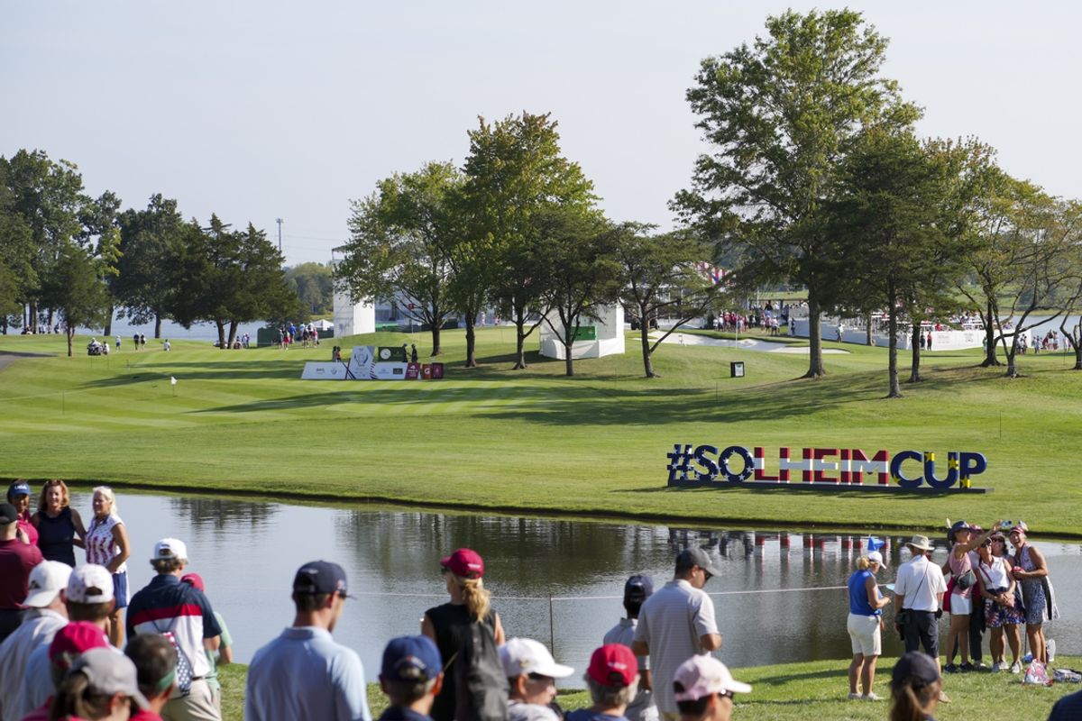 Sep 14, 2024; Gainesville, Virginia, USA; The Solheim Cup sign is seen as fans walk the course during Fourball matches between Team Europe and Team USA during the second round of the Solheim Cup 2024 at Robert Trent Jones Golf Club. Mandatory Credit: Aaron Doster-Imagn Images