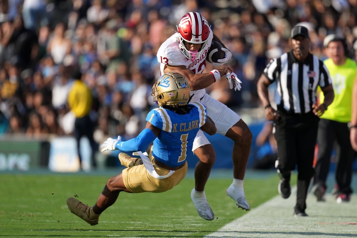 Sep 14, 2024; Pasadena, California, USA; Indiana Hoosiers wide receiver Elijah Sarratt (13) carries the ball against UCLA Bruins defensive back Kanye Clark (1) in the first half at Rose Bowl. Mandatory Credit: Kirby Lee-Imagn Images