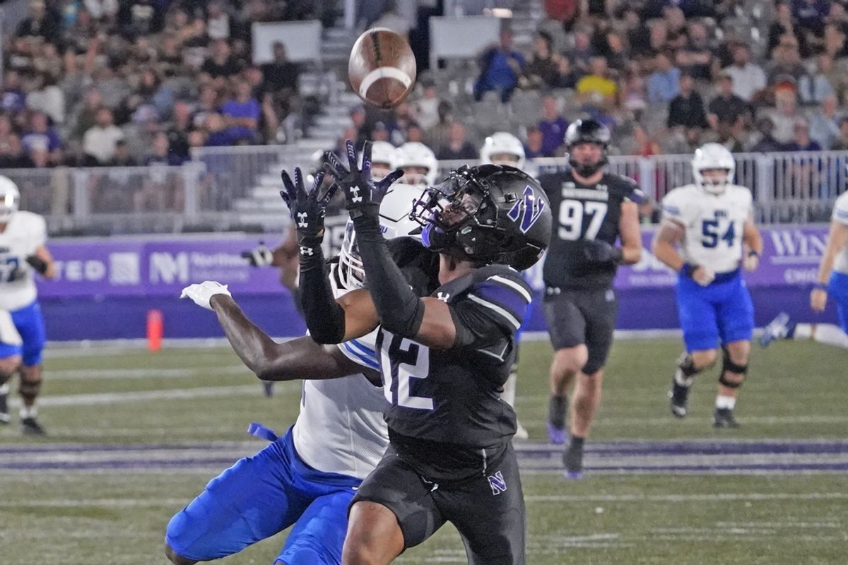 Sep 14, 2024; Evanston, Illinois, USA; Northwestern Wildcats defensive back Evan Smith (12) tries to intercept a pass to Eastern Illinois Panthers wide receiver Terrance Gipson (1) Northwestern Wildcats defensive back Evan Smith (12) during the first half at Lanny and Sharon Martin Stadium. Mandatory Credit: David Banks-Imagn Images