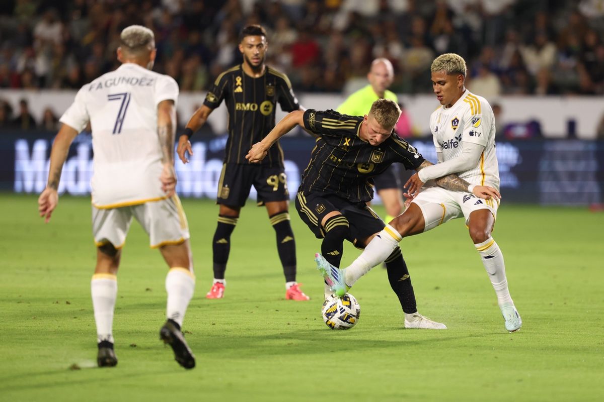 Sep 14, 2024; Carson, California, USA; LAFC midfielder Mateusz Bogusz (19) battles Los Angeles Galaxy midfielder Edwin Cerrillo (20) for the ball in the first half at Dignity Health Sports Park. Mandatory Credit: Kiyoshi Mio-Imagn Images