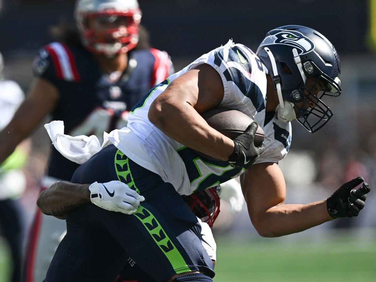 Sep 15, 2024; Foxborough, Massachusetts, USA; Seattle Seahawks running back Zach Charbonnet (26) runs with the ball against New England Patriots safety Kyle Dugger (23) during the first half at Gillette Stadium. Mandatory Credit: Brian Fluharty-Imagn Images