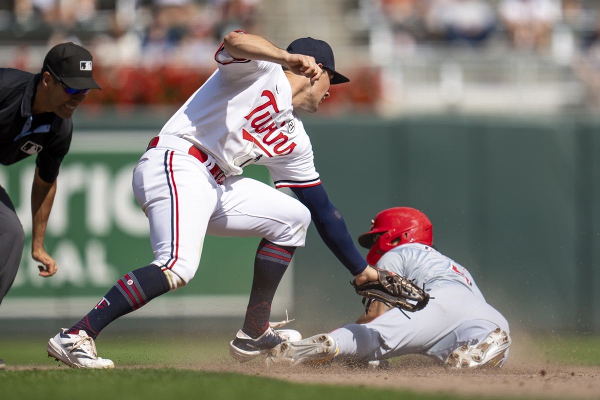 Sep 15, 2024; Minneapolis, Minnesota, USA; Cincinnati Reds third baseman Santiago Espinal (4) steals and slides into second base before Minnesota Twins shortstop Brooks Lee (72) can make a tag in the sixth inning at Target Field. Mandatory Credit: Jesse Johnson-Imagn Images