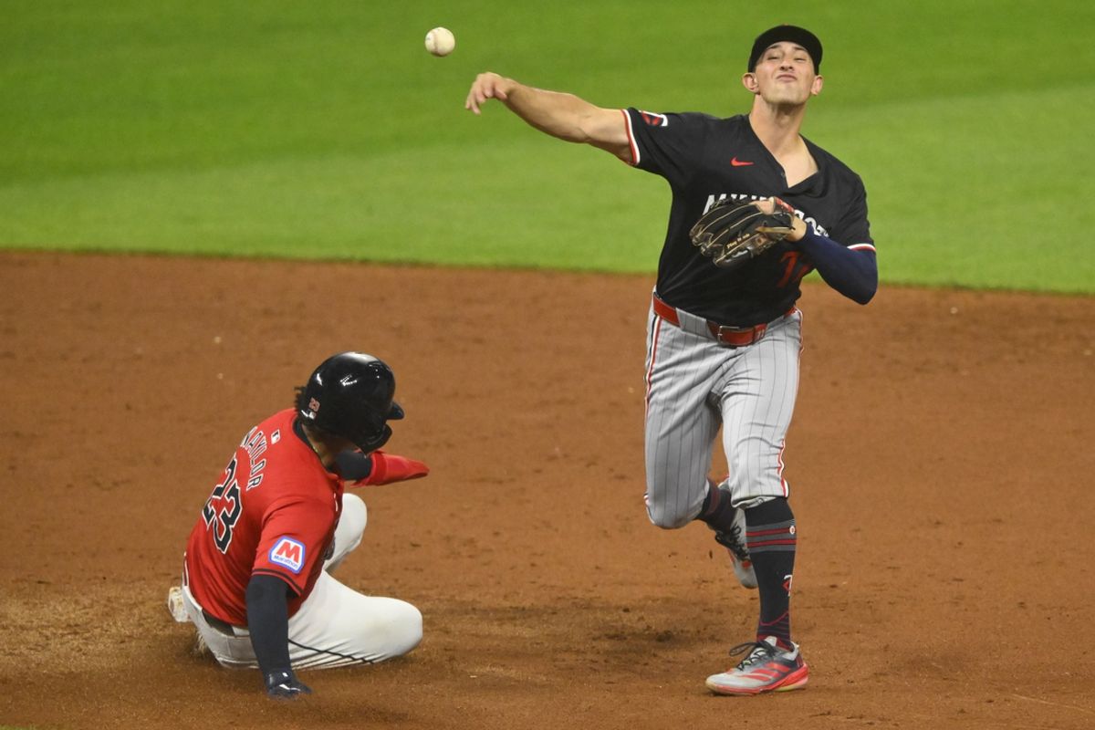 Sep 17, 2024; Cleveland, Ohio, USA; Minnesota Twins shortstop Brooks Lee (72) turns a double play beside Cleveland Guardians catcher Bo Naylor (23) in the fifth inning at Progressive Field. Mandatory Credit: David Richard-Imagn Images