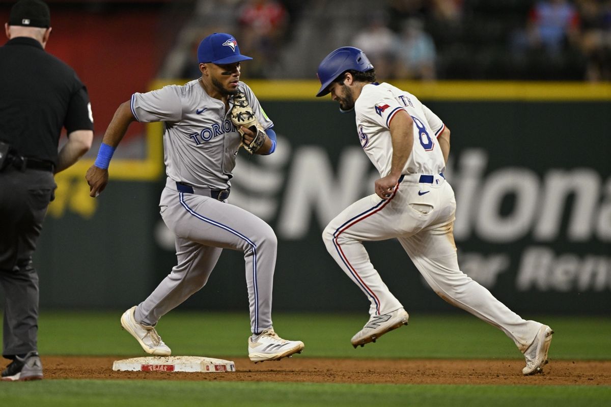 Sep 17, 2024; Arlington, Texas, USA; Toronto Blue Jays second baseman Leo Jimenez (49) puts out Texas Rangers shortstop Josh Smith (8) at second base during the fifth inning at Globe Life Field. Mandatory Credit: Jerome Miron-Imagn Images