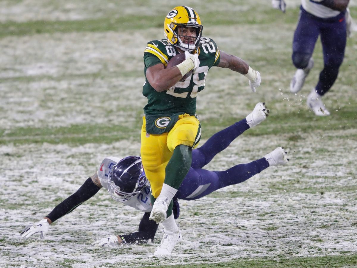 Green Bay Packers running back A.J. Dillon (28) breaks away from Tennessee Titans strong safety Kenny Vaccaro (24) for a touchdown run in the third quarter during their football game on December 27, 2020, at Lambeau Field in Green Bay, Wis.