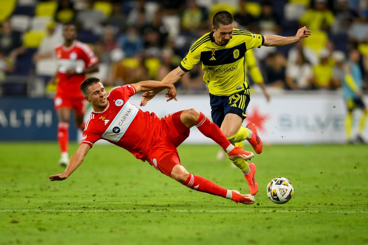 Sep 18, 2024; Nashville, Tennessee, USA;  Nashville SC midfielder Alex Muyl (19) and Chicago Fire defender Arnaud Souquet (2) fights for the ball during the first half at Geodis Park. Mandatory Credit: Steve Roberts-Imagn Images