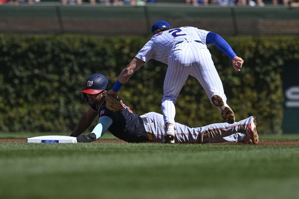 Sep 21, 2024; Chicago, Illinois, USA;  Chicago Cubs second baseman Nico Hoerner (2) tags out Washington Nationals second baseman Luis García Jr. (2) on an attempted steal during the first inning at Wrigley Field. Mandatory Credit: Matt Marton-Imagn Images