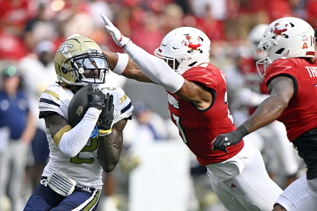 Sep 21, 2024; Louisville, Kentucky, USA;  Georgia Tech Yellow Jackets wide receiver Eric Singleton Jr. (2) catches a pass under the pressure of Louisville Cardinals defensive back Devin Neal (27) during the first half at L&N Federal Credit Union Stadium. Mandatory Credit: Jamie Rhodes-Imagn Images