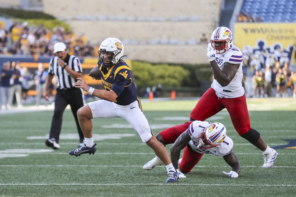 Sep 21, 2024; Morgantown, West Virginia, USA; West Virginia Mountaineers quarterback Garrett Greene (6) runs the ball and shakes out of a tackle during the fourth quarter against the Kansas Jayhawks at Mountaineer Field at Milan Puskar Stadium. Mandatory Credit: Ben Queen-Imagn Images