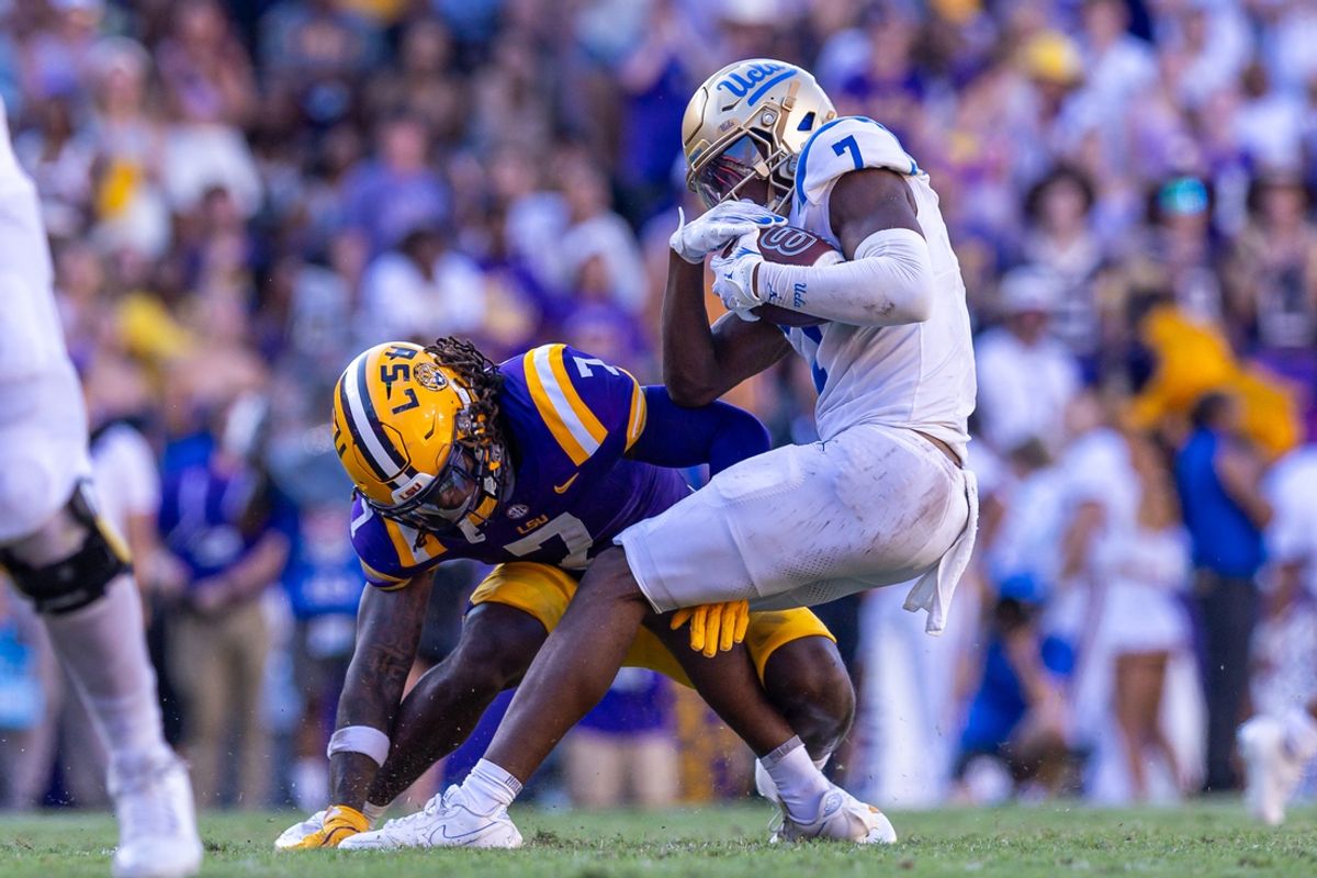 Sep 21, 2024; Baton Rouge, Louisiana, USA;  LSU Tigers linebacker Harold Perkins Jr. (7)  tackles UCLA Bruins wide receiver J.Michael Sturdivant (7) during the second half at Tiger Stadium. Mandatory Credit: Stephen Lew-Imagn Images