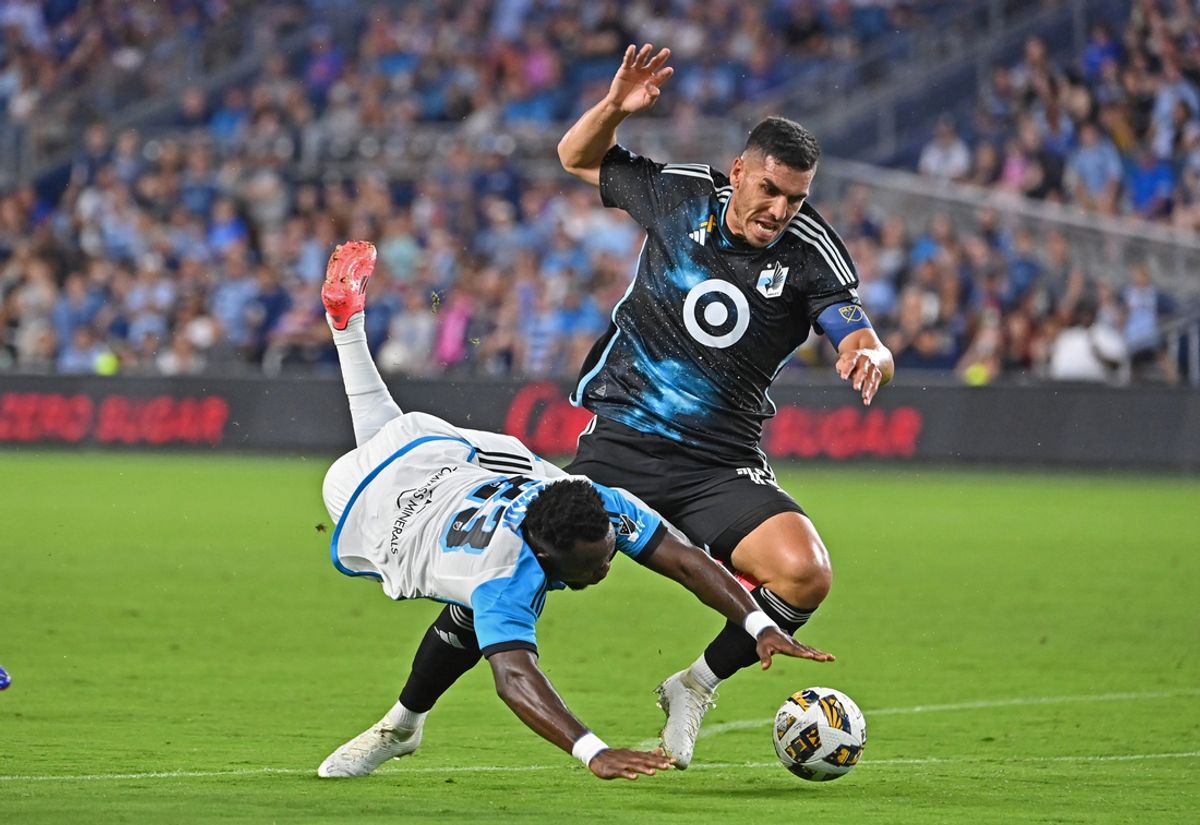 Sep 21, 2024; Kansas City, Kansas, USA;  Minnesota United defender Michael Boxall (15) and Sporting Kansas City forward Willy Agada (23) battle for the ball in the first half at Children's Mercy Park. Mandatory Credit: Peter Aiken-Imagn Images