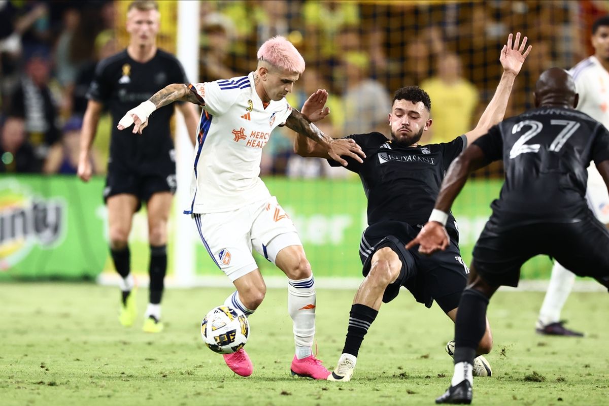 Sep 21, 2024; Nashville, Tennessee, USA; Nashville SC midfielder Patrick Yazbek (15) kicks the ball away from FC Cincinnati midfielder Luca Orellano (23) in the first half at Geodis Park. Mandatory Credit: Casey Gower-Imagn Images