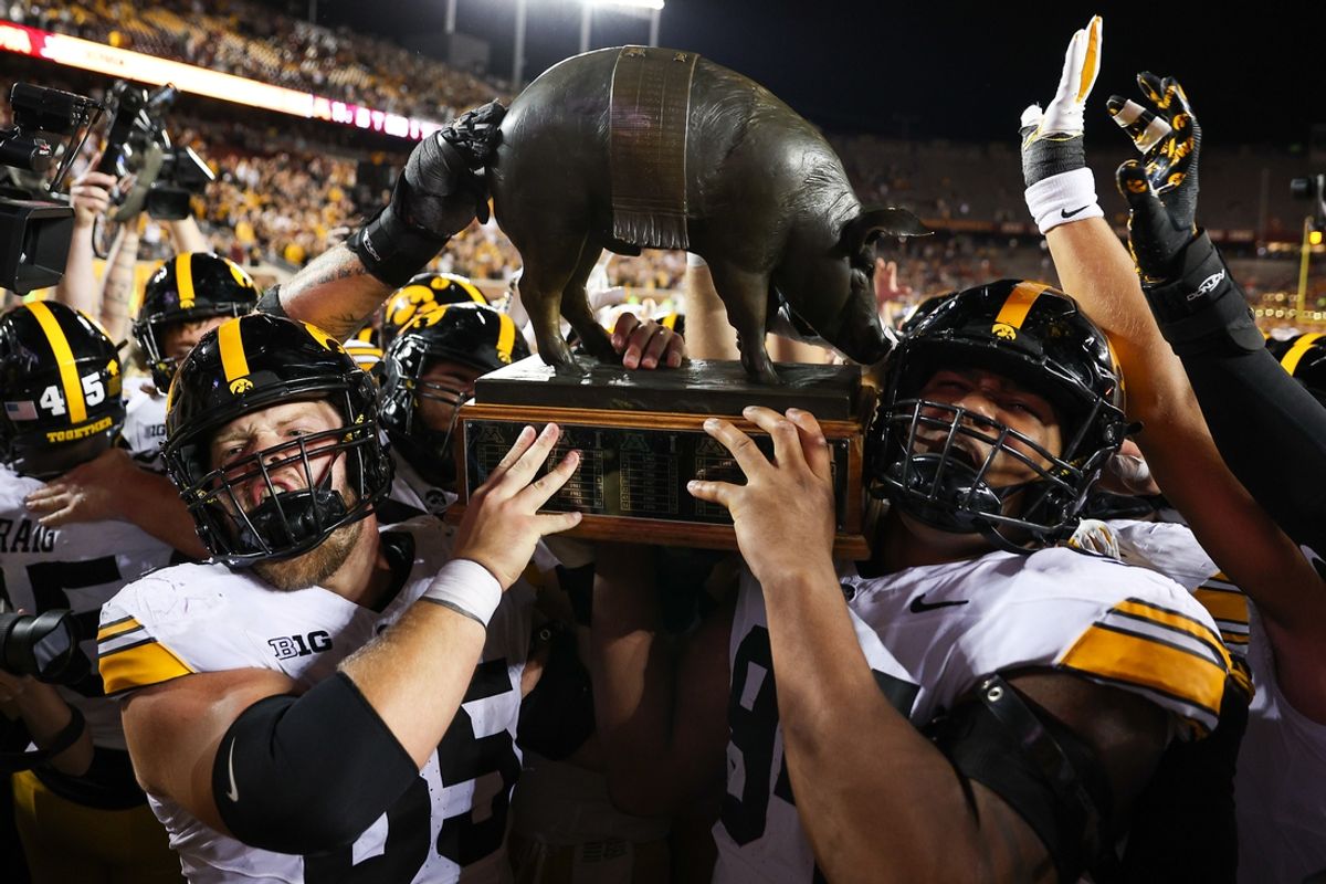 Sep 21, 2024; Minneapolis, Minnesota, USA; Iowa Hawkeyes offensive lineman Logan Jones (65) and defensive lineman Yahya Black (94) celebrate with the Floyd of Rosedale trophy after the game against the Minnesota Golden Gophers at Huntington Bank Stadium. Mandatory Credit: Matt Krohn-Imagn Images