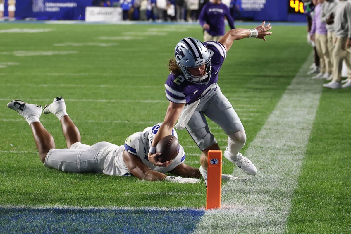 Sep 21, 2024; Provo, Utah, USA; Kansas State Wildcats quarterback Avery Johnson (2) reaches for a touchdown against Brigham Young Cougars defensive end Logan Lutui (59) during the third quarter at LaVell Edwards Stadium. Mandatory Credit: Rob Gray-Imagn Images