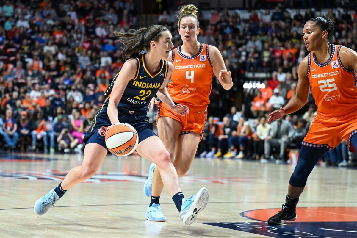 Sep 22, 2024; Uncasville, Connecticut, USA; Indiana Fever guard Caitlin Clark (22) dribbles the ball against Connecticut Sun forward Alyssa Thomas (25) and Connecticut Sun guard Marina Mabrey (4) in the second quarter during game one of the first round of the 2024 WNBA Playoffs at Mohegan Sun Arena. Mandatory Credit: Mark Smith-Imagn Images