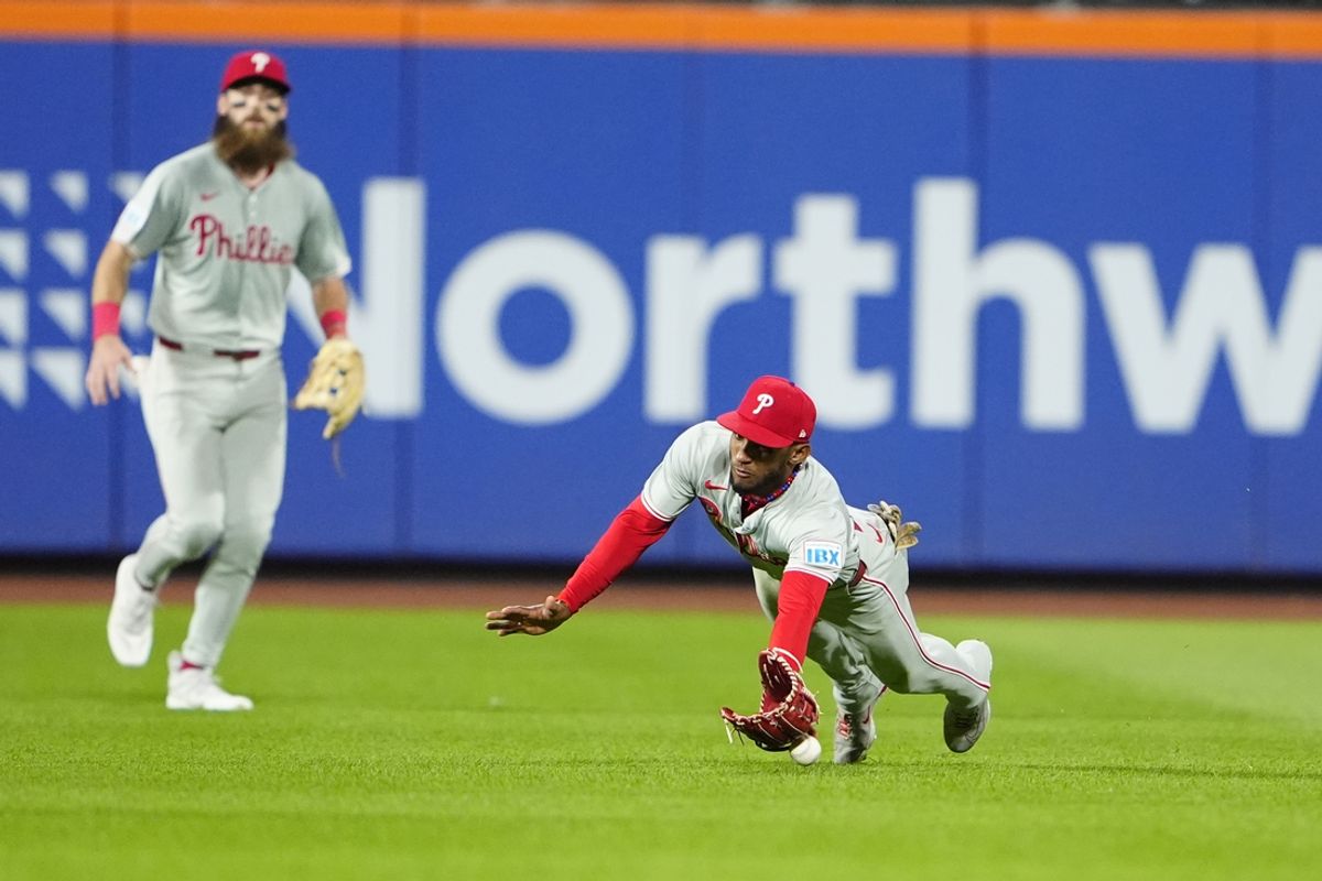 Sep 22, 2024; New York City, New York, USA; Philadelphia Phillies center fielder Johan Rojas (18) attempts to catch a fly ball hit by New York Mets center fielder Tyrone Taylor (not pictured) during the fifth inning at Citi Field. Mandatory Credit: Gregory Fisher-Imagn Images