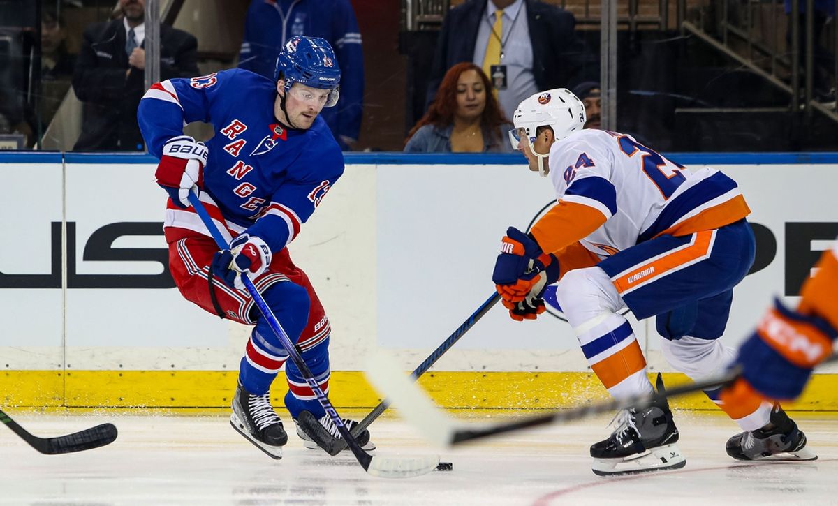Sep 24, 2024; New York, New York, USA; New York Rangers left wing Alexis Lafreniere (13) controls the puck as New York Islanders defenseman Scott Mayfield (24) defends during the first period at Madison Square Garden. Mandatory Credit: Danny Wild-Imagn Images