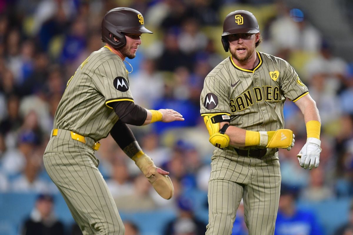 Sep 24, 2024; Los Angeles, California, USA; San Diego Padres second baseman Jake Cronenworth (9) is greeted by center fielder Jackson Merrill (3) after hitting a two run home run against the Los Angeles Dodgers during the second inning at Dodger Stadium. Mandatory Credit: Gary A. Vasquez-Imagn Images