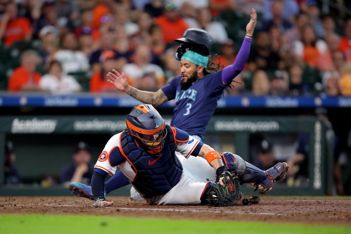 Sep 25, 2024; Houston, Texas, USA; Houston Astros designated hitter Yainer Diaz (21) catches a fielded ball as Seattle Mariners shortstop J.P. Crawford (3) slides into home plate to score a run during the seventh inning at Minute Maid Park. Mandatory Credit: Erik Williams-Imagn Images
