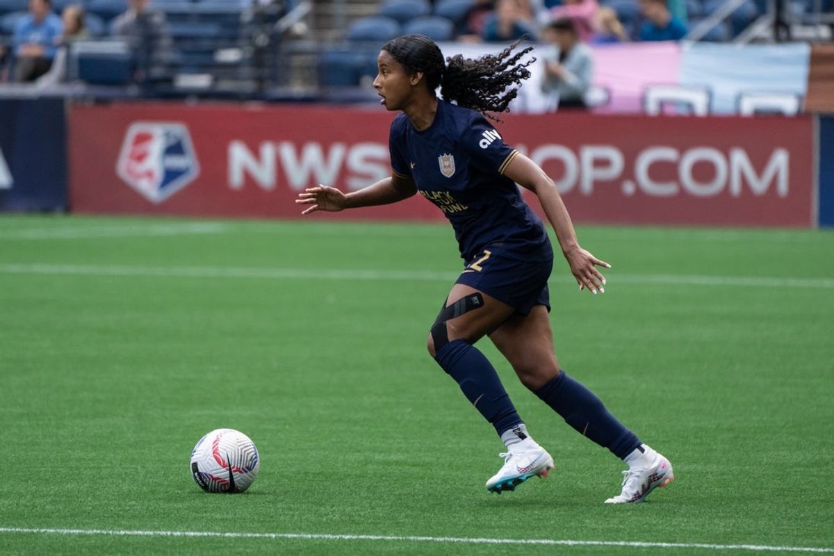 Jun 16, 2024; Seattle, Washington, USA; Seattle Reign defender Ryanne Brown (22) dribbles the ball against the Portland Thorns at Lumen Field. Mandatory Credit: Stephen Brashear-USA TODAY Sports