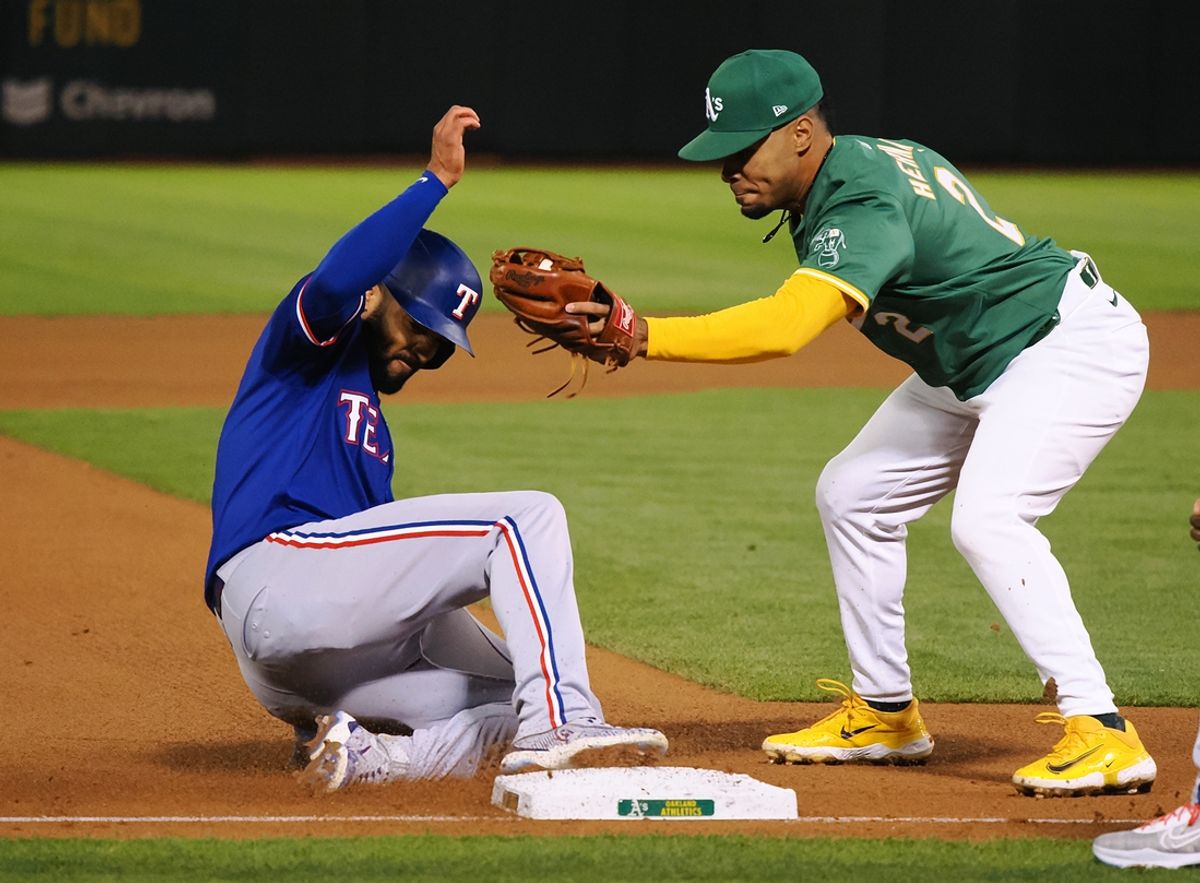 Sep 25, 2024; Oakland, California, USA; Texas Rangers second baseman Marcus Semien (2) safe at third base against Oakland Athletics third baseman Darell Hernaiz (2) during the fourth inning at Oakland-Alameda County Coliseum. Mandatory Credit: Kelley L Cox-Imagn Images