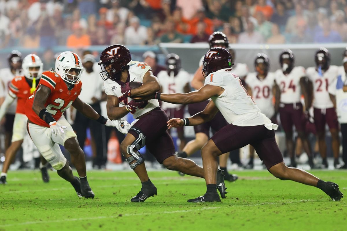 Sep 27, 2024; Miami Gardens, Florida, USA; Virginia Tech Hokies running back Bhayshul Tuten (33) takes a handoff from quarterback Kyron Drones (1) against the Miami Hurricanes during the fourth quarter at Hard Rock Stadium. Mandatory Credit: Sam Navarro-Imagn Images