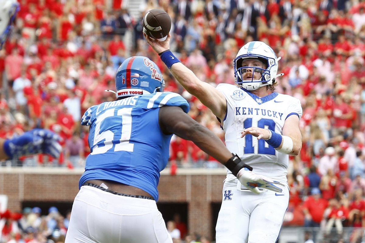 Sep 28, 2024; Oxford, Mississippi, USA; Kentucky Wildcats quarterback Brock Vandagriff (12) passes the ball for a touchdown as Mississippi Rebels defensive linemen Zxavian Harris (51) pursues during the first half at Vaught-Hemingway Stadium. Mandatory Credit: Petre Thomas-Imagn Images
