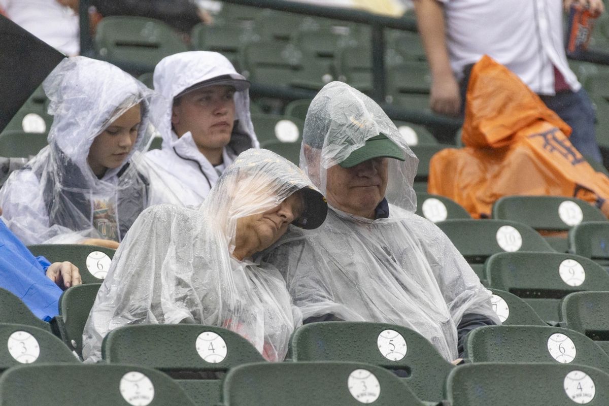 Sep 28, 2024; Detroit, Michigan, USA; Fans in rain gear look on during a rain delay prior to the game between the Detroit Tigers and the Chicago White Sox at Comerica Park. Mandatory Credit: Brian Bradshaw Sevald-Imagn Images