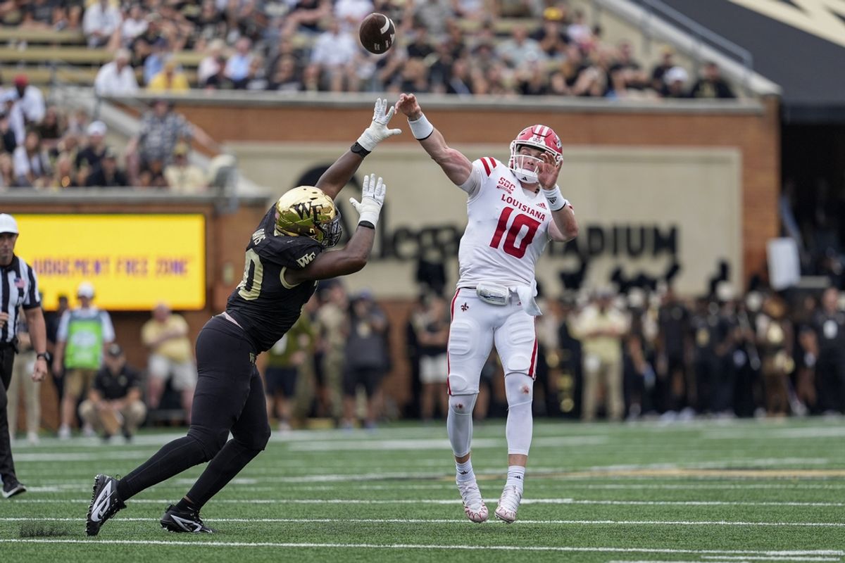 Sep 28, 2024; Winston-Salem, North Carolina, USA;  Louisiana-Lafayette Ragin Cajuns quarterback Ben Wooldridge (10) throws a touchdown pass under pressure by Wake Forest Demon Deacons defensive lineman Jasheen Davis (30) during the first half at Allegacy Federal Credit Union Stadium. Mandatory Credit: Jim Dedmon-Imagn Images