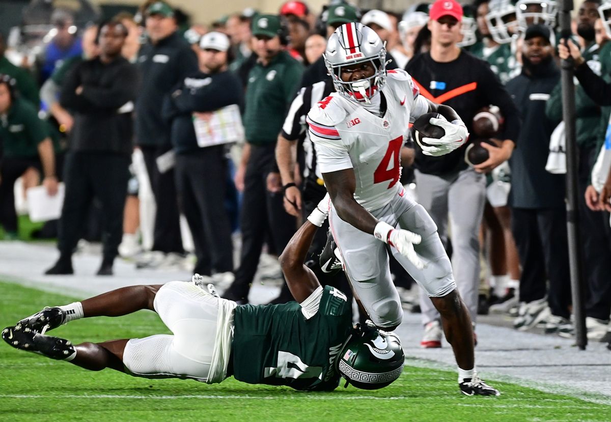 Sep 28, 2024; East Lansing, Michigan, USA;  Ohio State Buckeyes wide receiver Jeremiah Smith (4) runs past Michigan State Spartans defensive back Ed Woods (4) in the first quarter at Spartan Stadium. Mandatory Credit: Dale Young-Imagn Images