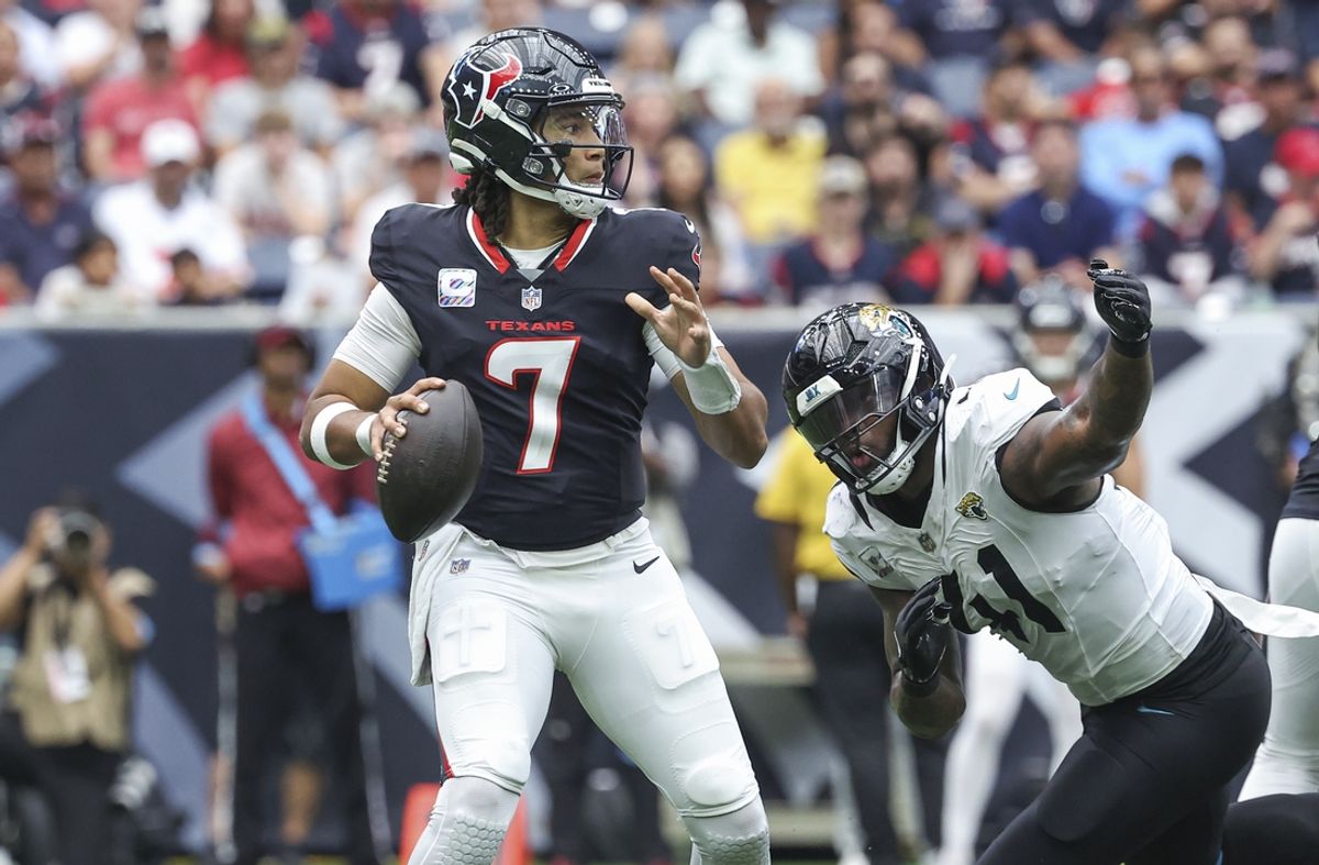 Sep 29, 2024; Houston, Texas, USA; Houston Texans quarterback C.J. Stroud (7) looks for an open receiver as Jacksonville Jaguars defensive end Josh Hines-Allen (41) applies defensive pressure during the second quarter at NRG Stadium. Mandatory Credit: Troy Taormina-Imagn Images