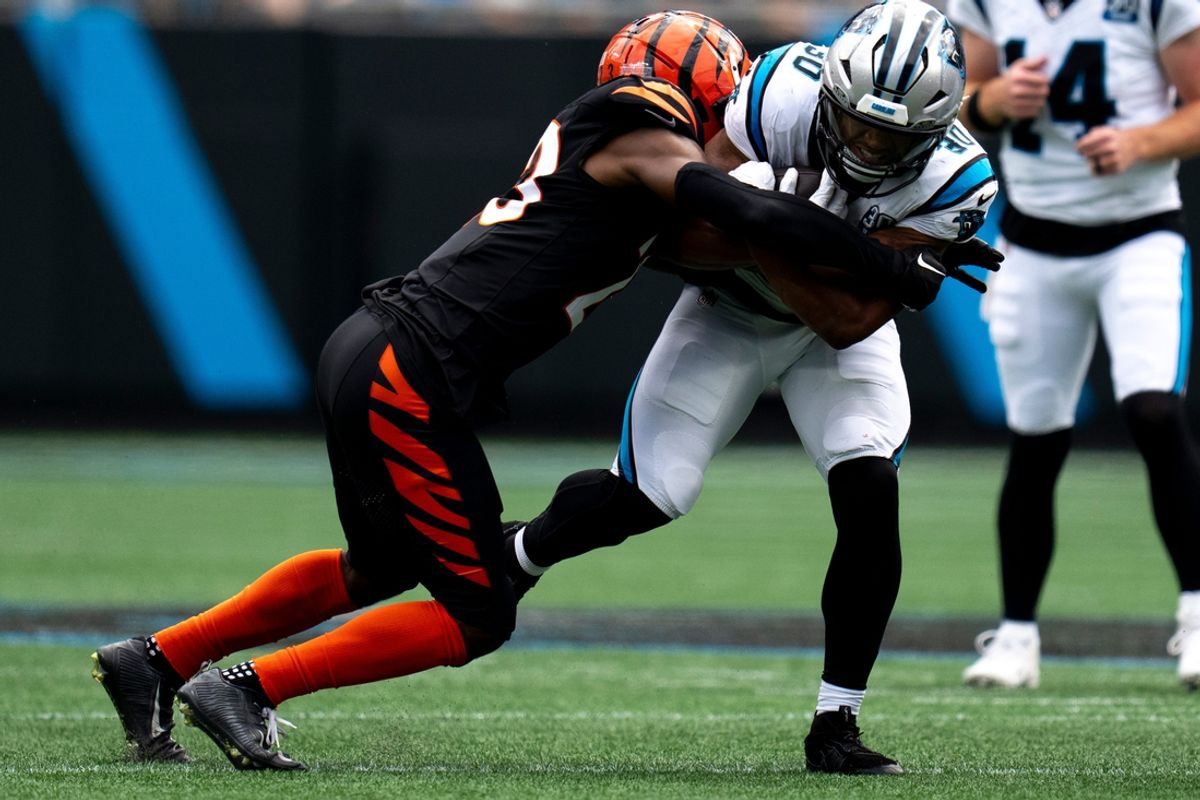 Cincinnati Bengals cornerback Dax Hill (23) tackles Carolina Panthers running back Chuba Hubbard (30) in the second quarter of the NFL game at Bank of America Stadium in Charlotte, N.C., on Sunday, Sept. 29, 2024.