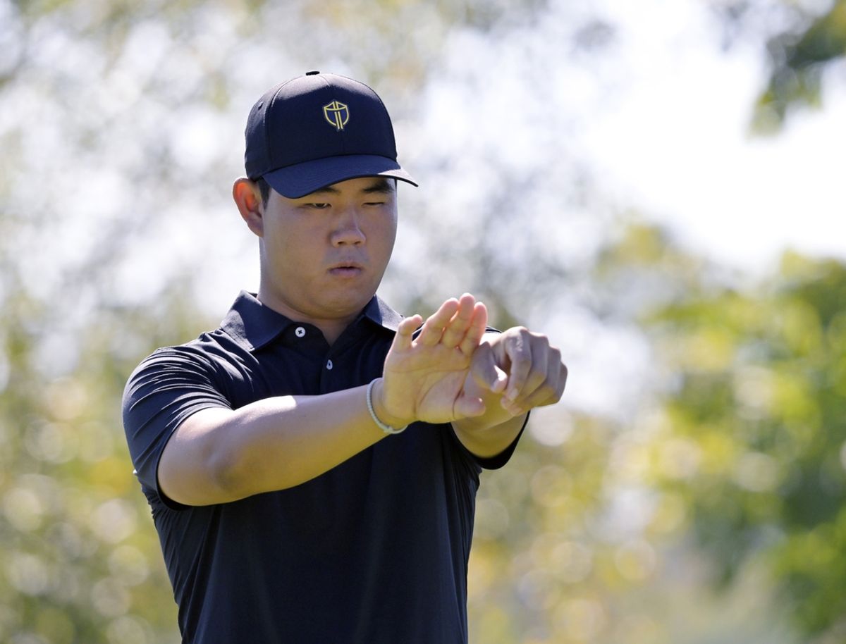 Sep 29, 2024; Ile Bizard, Quebec, CAN; Tom Kim of the International team lines up his putt on the green of the first hole in singles match during the final round of The Presidents Cup golf tournament. Mandatory Credit: Eric Bolte-Imagn Images