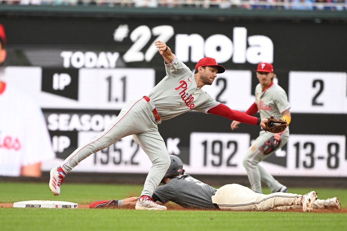 Sep 29, 2024; Washington, District of Columbia, USA; Philadelphia Phillies shortstop Trea Turner (7) stretches to catch a throw as Washington Nationals right fielder Dylan Crews (3) steals second base during the second inning at Nationals Park. Mandatory Credit: Rafael Suanes-Imagn Images