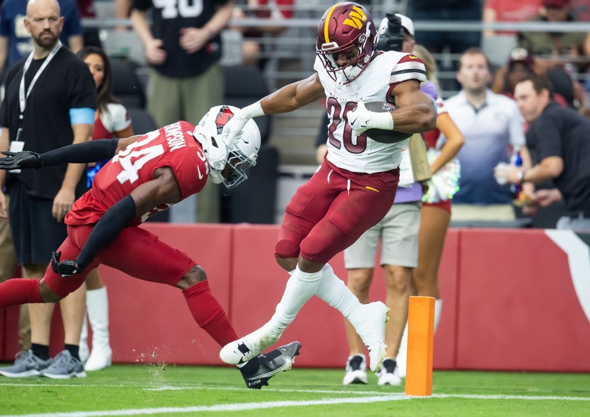 Sep 29, 2024; Glendale, Arizona, USA; Washington Commanders running back Jeremy McNichols (26) scores a touchdown against the Arizona Cardinals in the first half at State Farm Stadium. Mandatory Credit: Mark J. Rebilas-Imagn Images