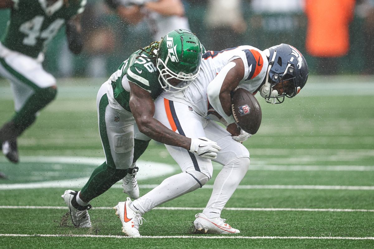 Sep 29, 2024; East Rutherford, New Jersey, USA; Denver Broncos running back Tyler Badie (28) fumbles after being hit by New York Jets linebacker Quincy Williams (56) during the first half at MetLife Stadium. Mandatory Credit: Vincent Carchietta-Imagn Images