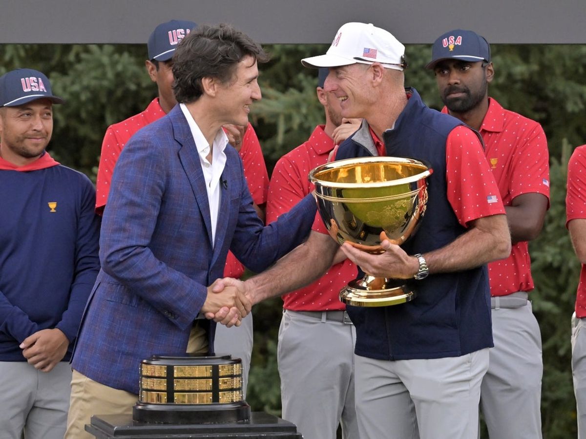 Sep 29, 2024; Ile Bizard, Quebec, CAN; Canana prime minister Justin Trudeau hands the trophy to Team USA captain Jim Furyk after the final round of The Presidents Cup golf tournament. Mandatory Credit: Eric Bolte-Imagn Images