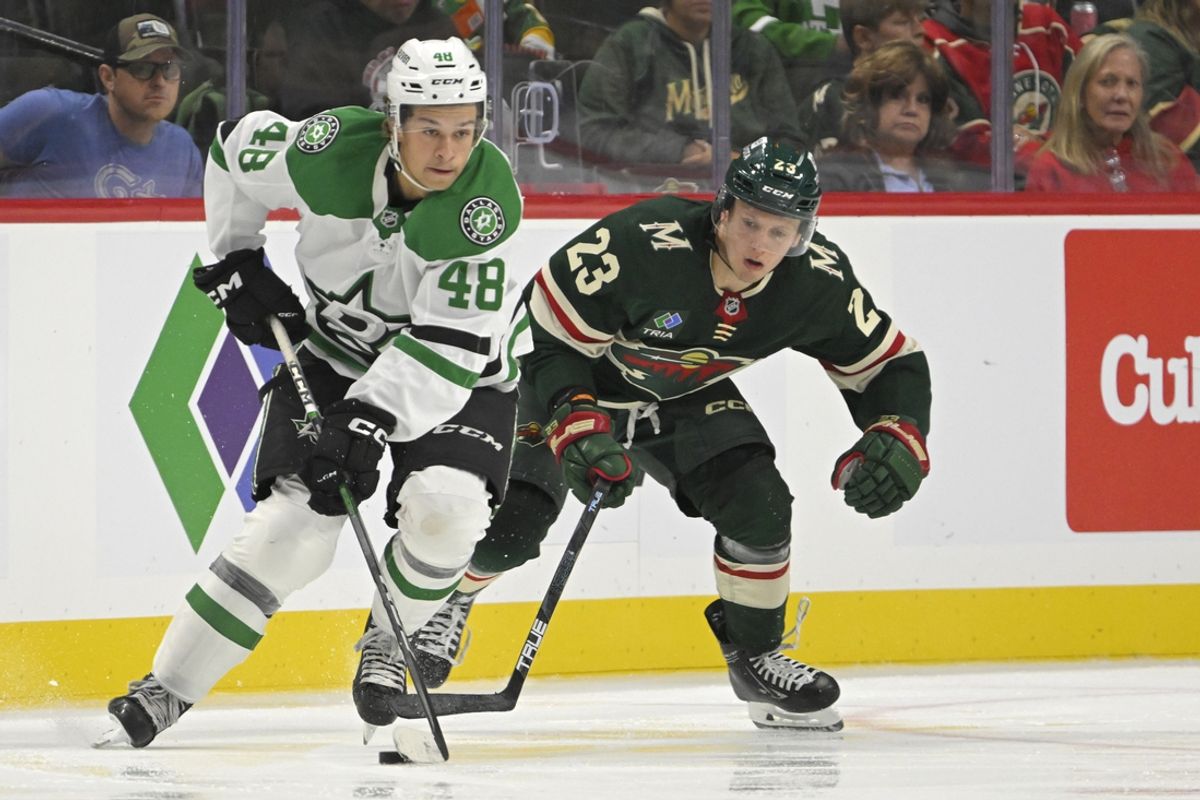 Sep 29, 2024; Saint Paul, Minnesota, USA;  Dallas Stars forward Chase Wheatcroft (48) protects the puck from Minnesota Wild forward Marco Rossi (23) during the second period at Xcel Energy Center. Mandatory Credit: Nick Wosika-Imagn Images