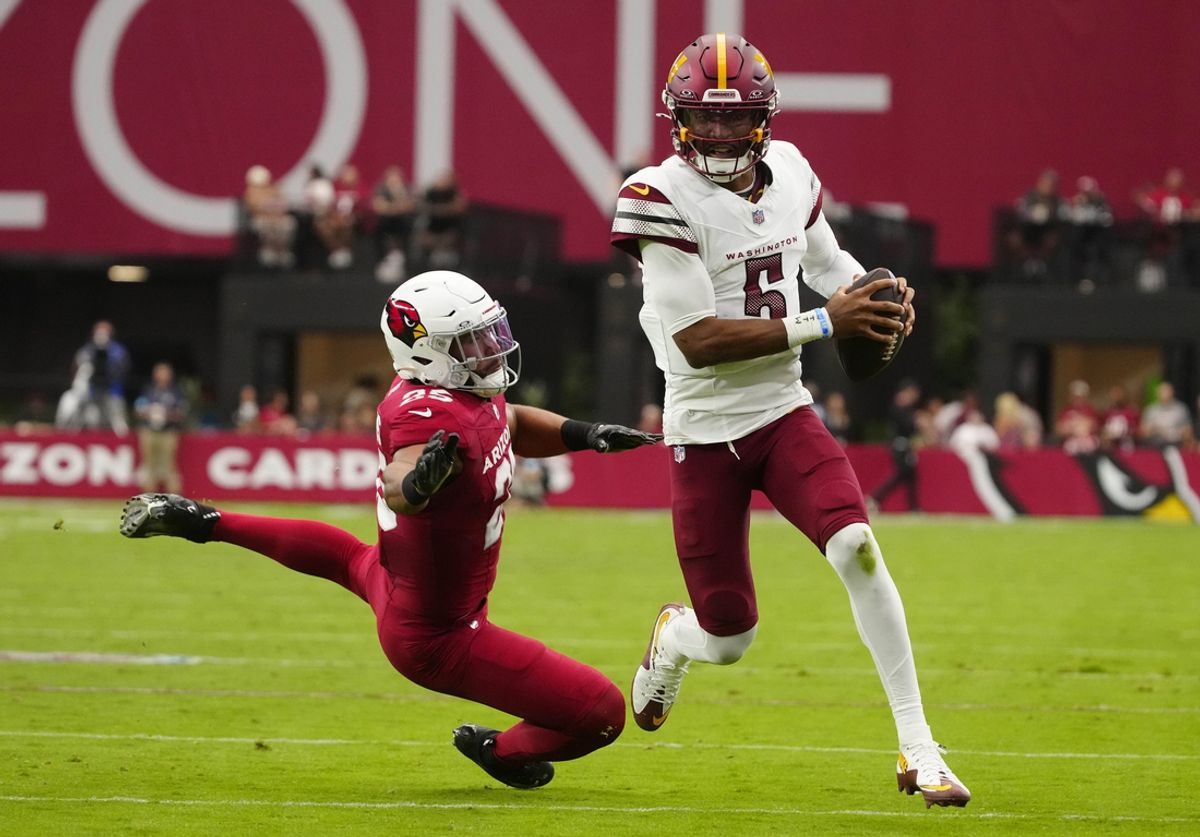 Commanders quarterback Jayden Daniels (5) scrambles out of the pocket against the Cardinals linebacker Zaven Collins (25) during a game at State Farm Stadium in Glendale on Sept. 29, 2024.