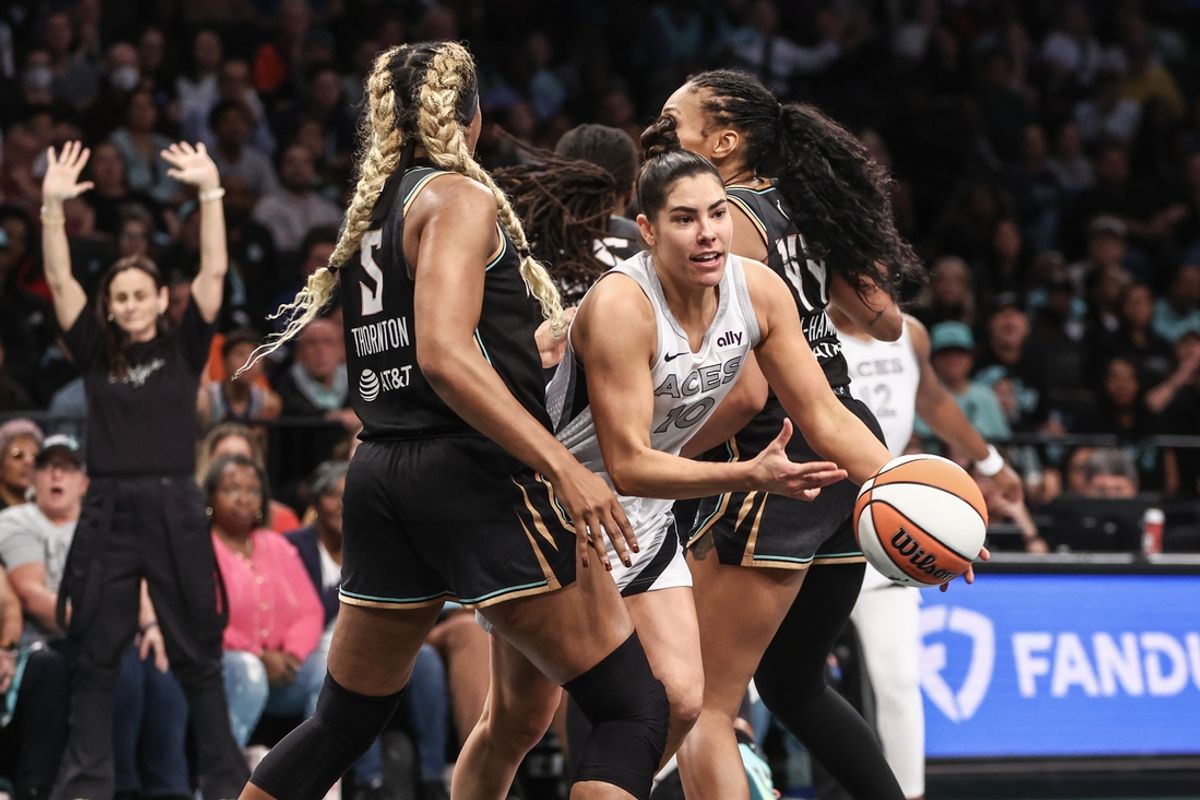Oct 1, 2024; Brooklyn, New York, USA; Las Vegas Aces guard Kelsey Plum (10) drives past New York Liberty forwards Kayla Thornton (5) and Betnijah Laney-Hamilton (44) during game two of the 2024 WNBA Semi-finals at Barclays Center. Mandatory Credit: Wendell Cruz-Imagn Images